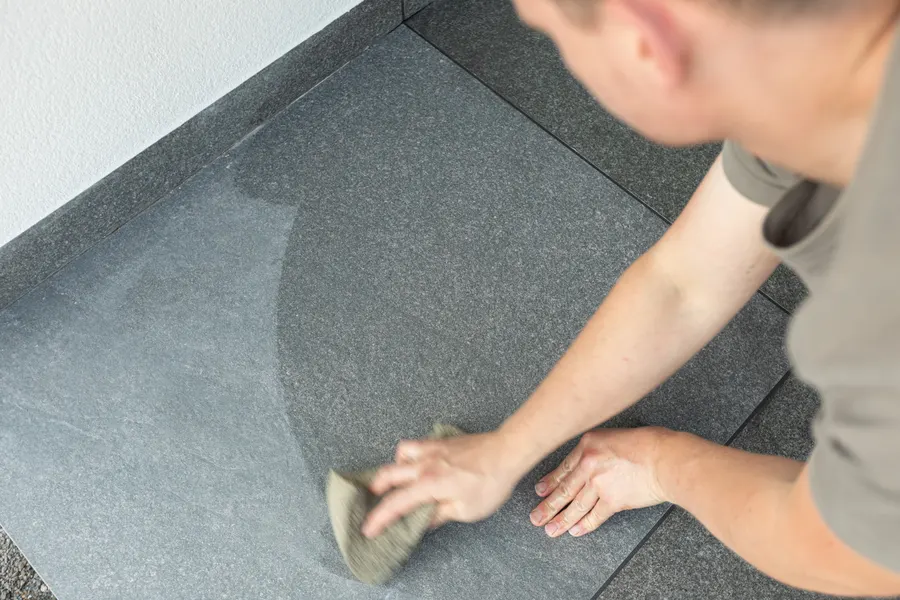 Fliesenleger von Linnemeier reinigt frisch verlegte Bodenfliesen