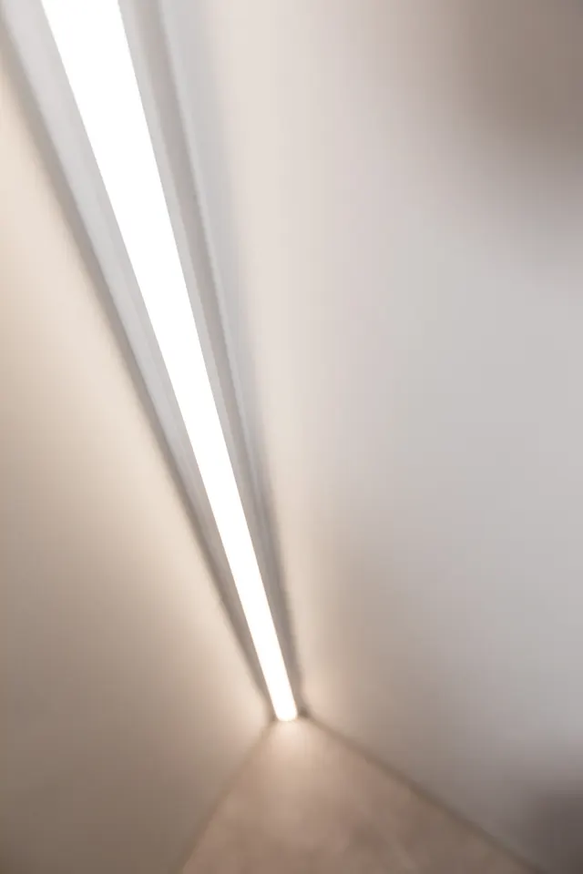 Großformatige Fliesen an Wand und Boden mit Lichtleiste